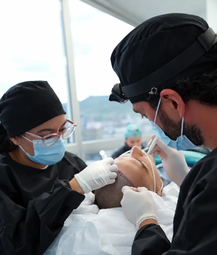 Equipo médico de Clínica Be Dharma realizando un implante capilar con técnica FUE manual en Medellín, Colombia, mediante extracción e implantación folicular de precisión