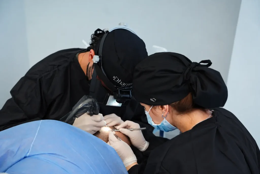 Equipo médico especializado realizando un implante capilar con técnica FUE manual en Clínica Be Dharma, Medellín, Colombia, mediante instrumental de precisión